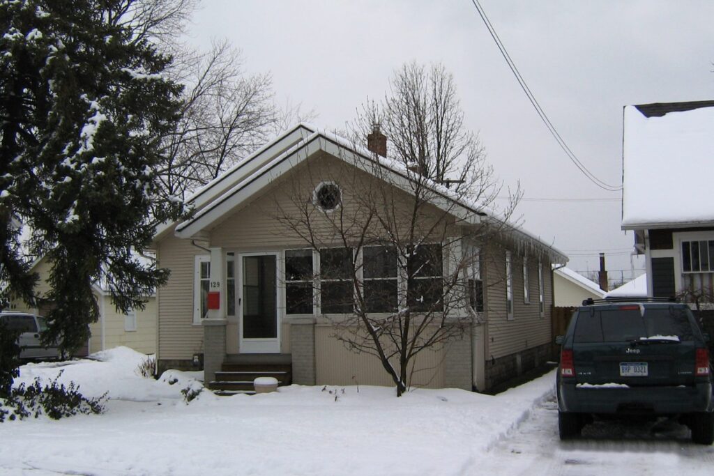 129 Albertson St.-Beige house in snow.